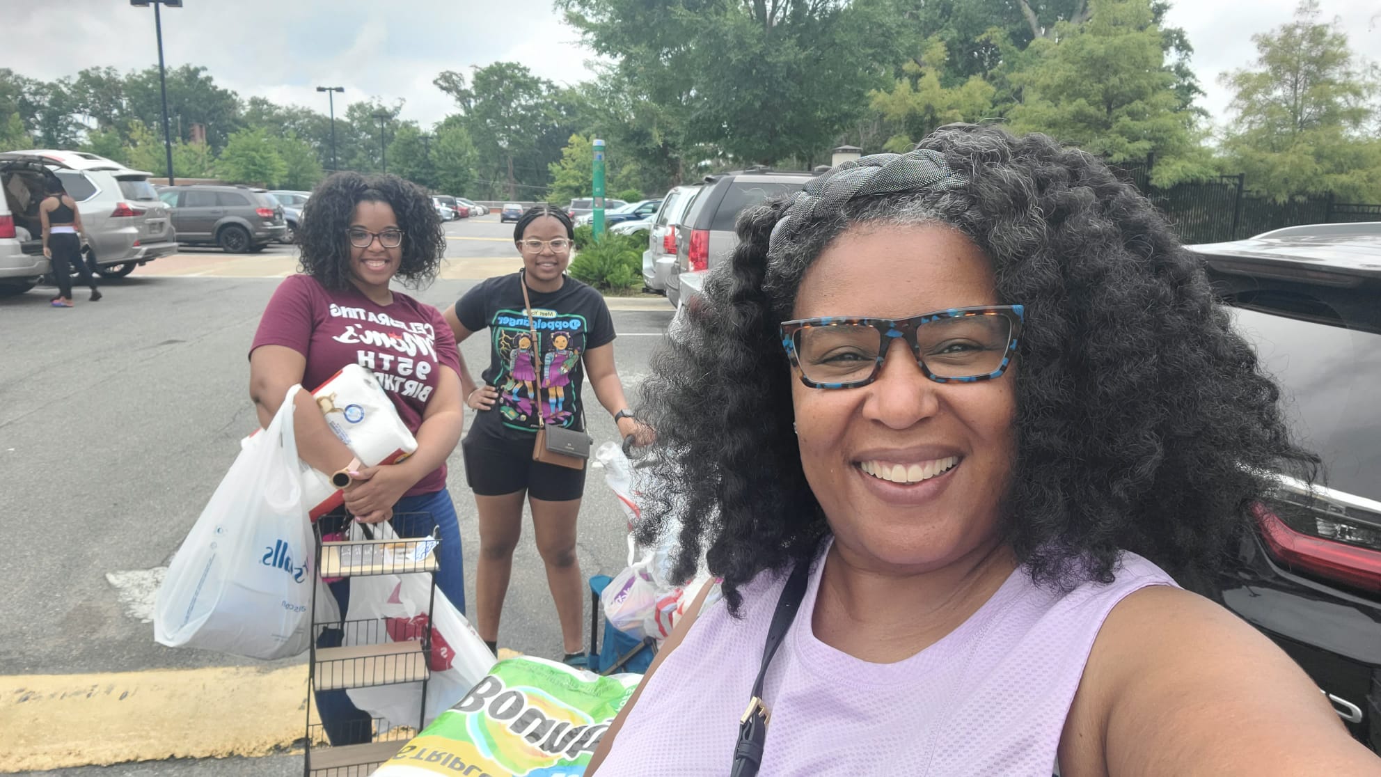 Telanna Jeffers, Mercedes Swan and Trinitee Jeffers a Mother and two daughters in a parking lot after shopping.